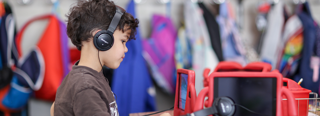 Student wearing headphones using a tablet device