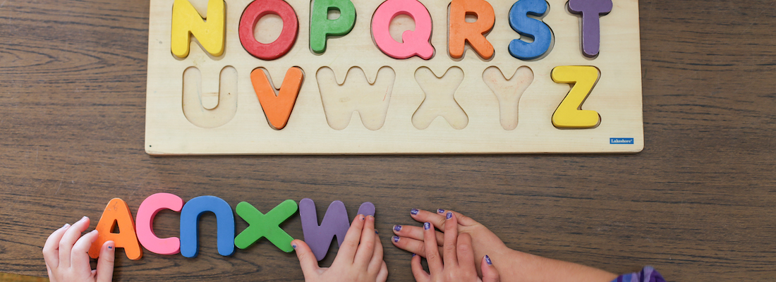 Students' hands using an alphabet puzzle activity