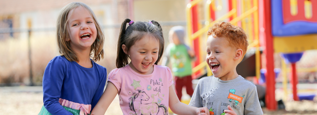3 students laughing on the playground